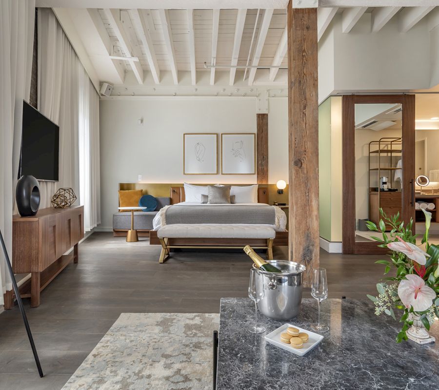 A luxurious hotel room with a king-size bed, flat-screen TV, and marble countertop