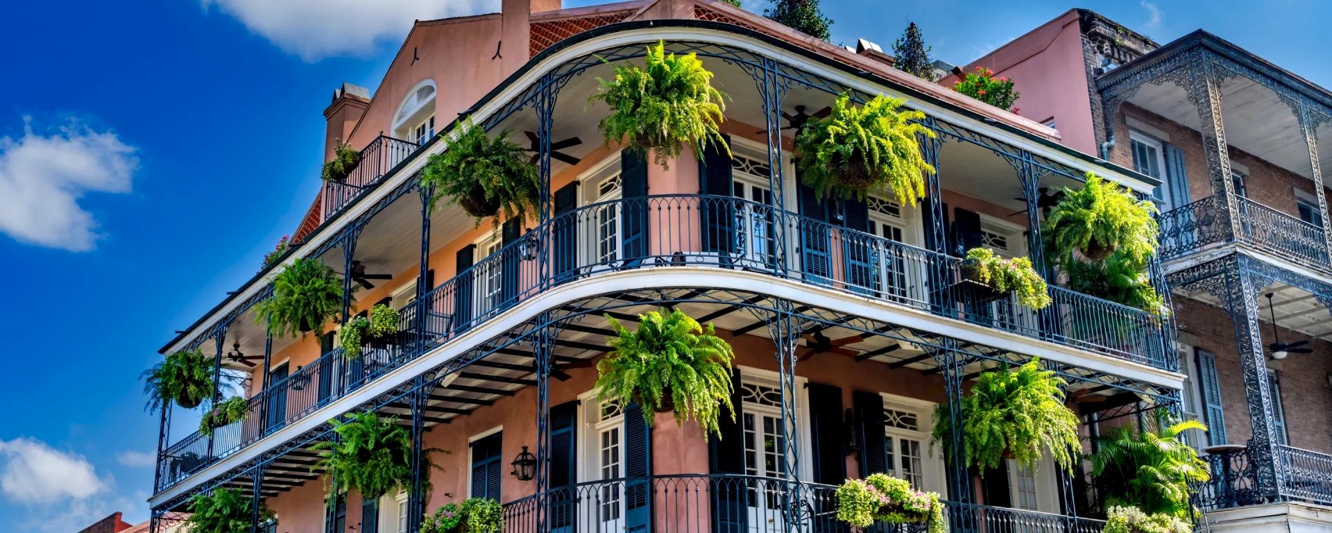 A multi-story building with balconies and plants.