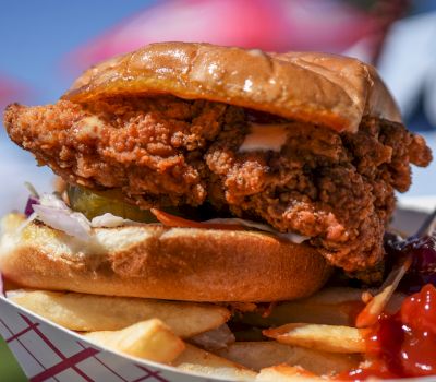 a close-up of a fried chicken sandwich and fries