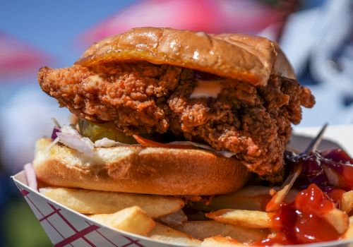 A crispy fried chicken sandwich in a bun, with fries and ketchup on the side.