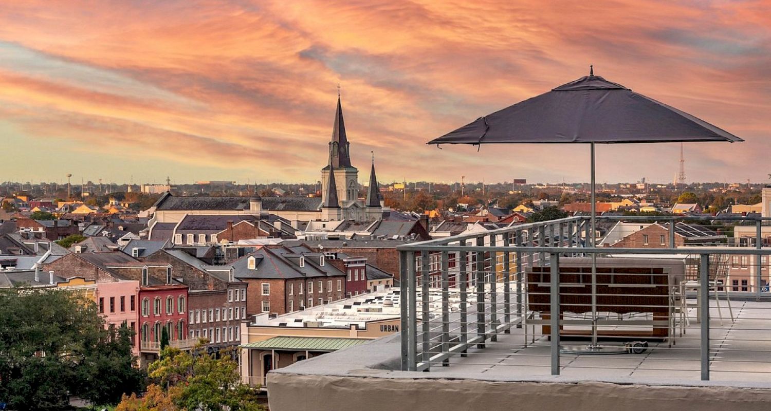 A rooftop patio with a view of the city at sunset.