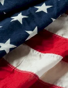 A close-up of an American flag fabric showing blue with white stars and red-and-white stripes.