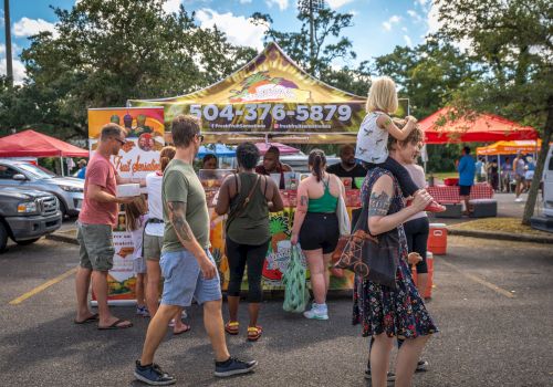 A crowd browses a Fresh Fruit Sensations food truck stand at an outdoor event under a sunny tent.